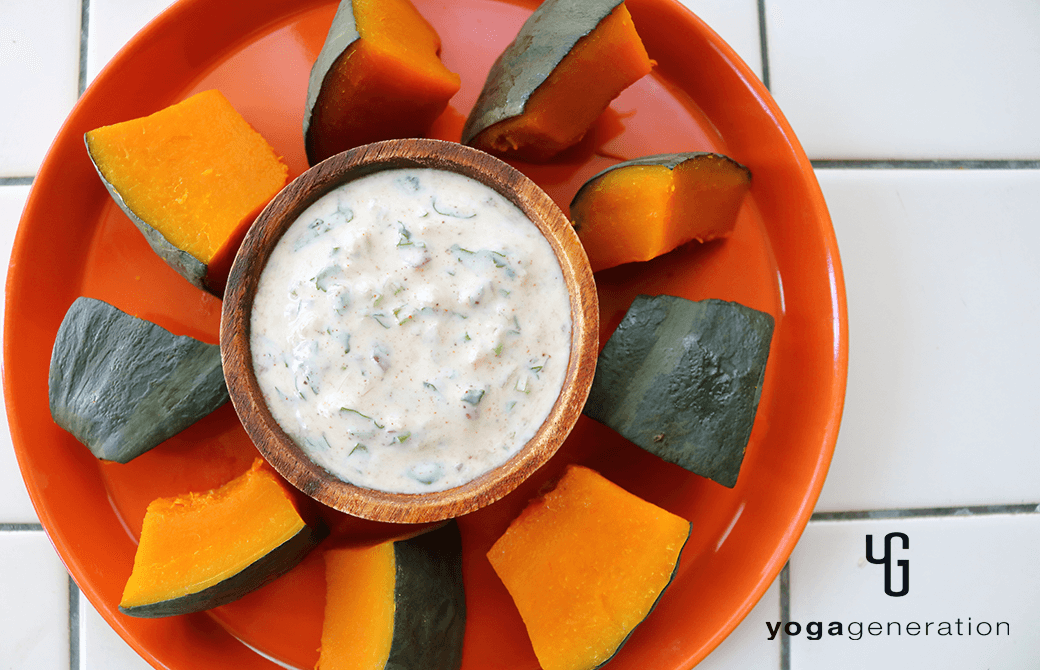 オレンジのお皿に盛り付けたスパイシーヨーグルトソースで楽しむ蒸しカボチャ