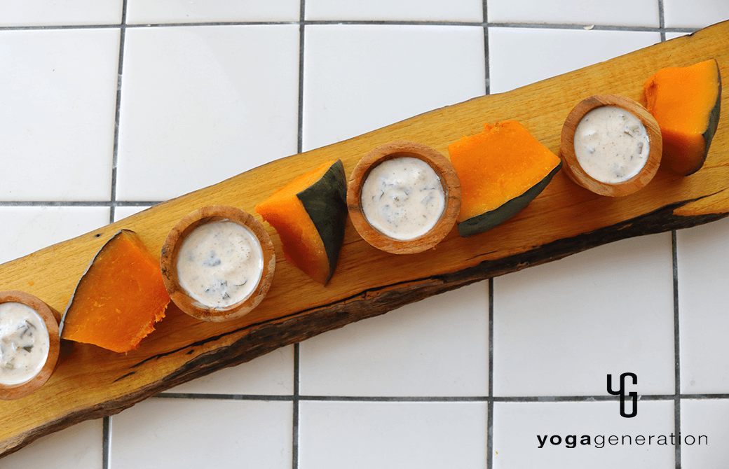 カッティングボードに盛り付けた、スパイシーヨーグルトソースで楽しむ蒸しカボチャ