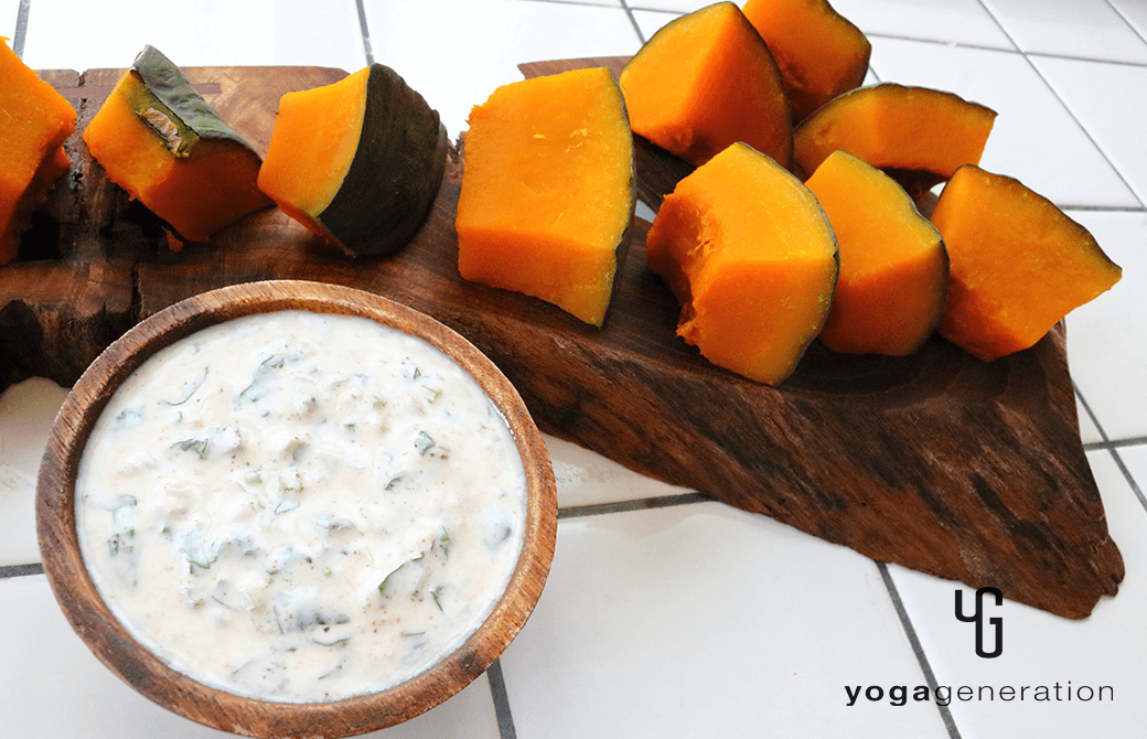 カッティングボードに盛り付けた、スパイシーヨーグルトソースで楽しむ蒸しカボチャ