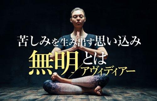 暗がりで明かりを受けて座るヨガ実践者の女性