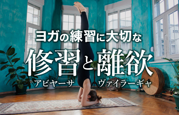 室内でヘッドスタンドをする黒いウェアを着た女性