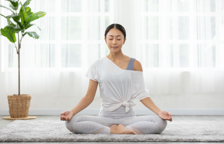 室内で安楽座で座る女性