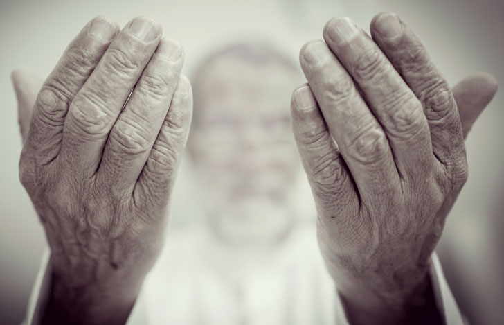 老人の手とその後ろにぼんやりと映る老人の顔