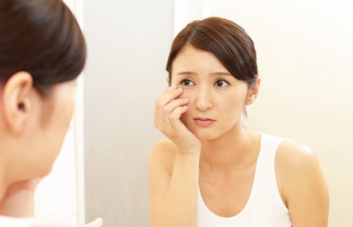 鏡の前で頬杖つく女性