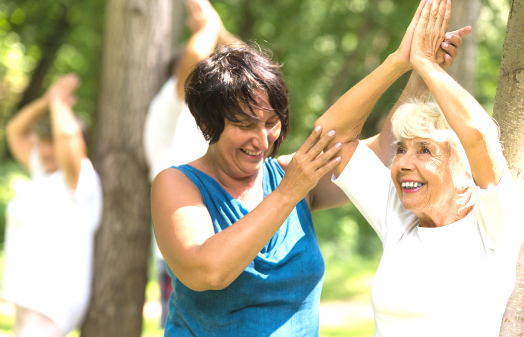 手を添えるヨガインストラクターと老女