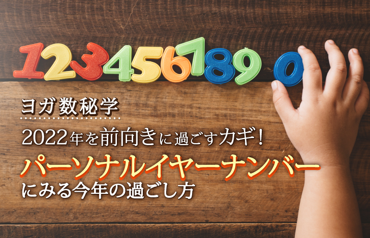 木の机の上で数字のフィギュアを手に取ろうとする子供の手