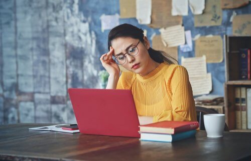 パソコンを見て考え込む女性