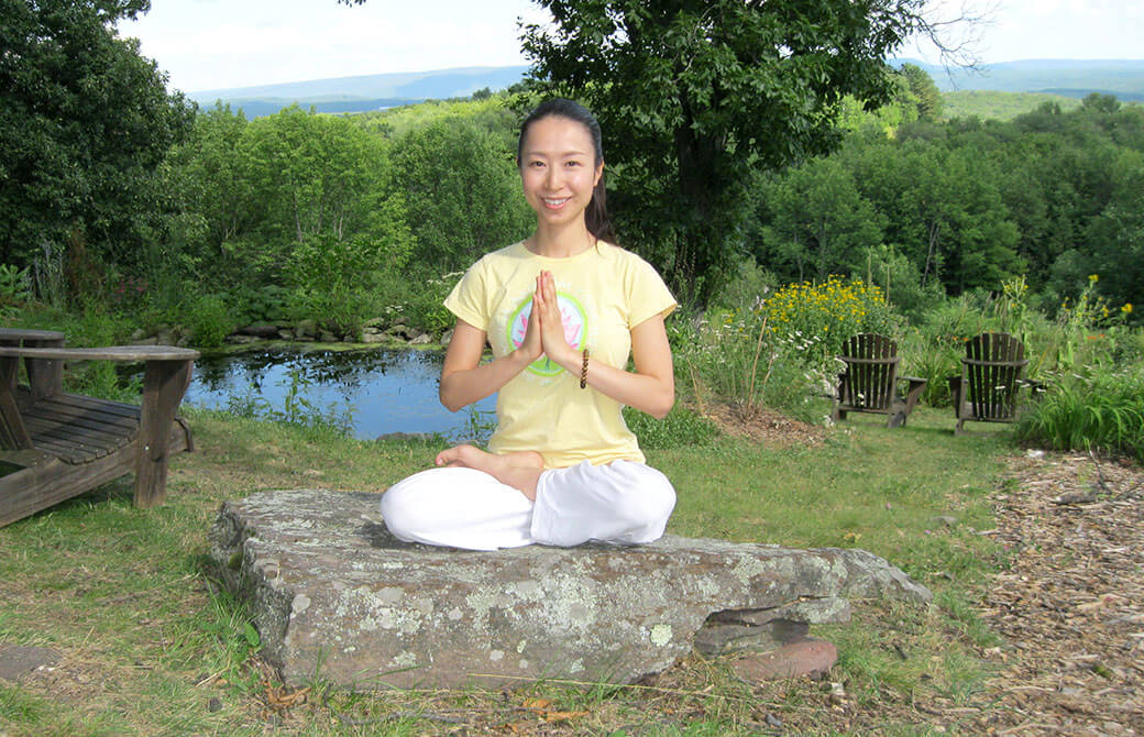 岩の上でハーフロータスで座る女性