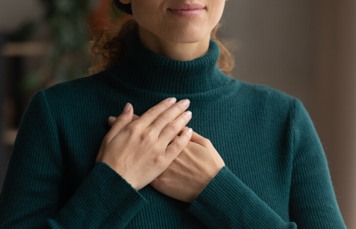 胸に手を当てている女性