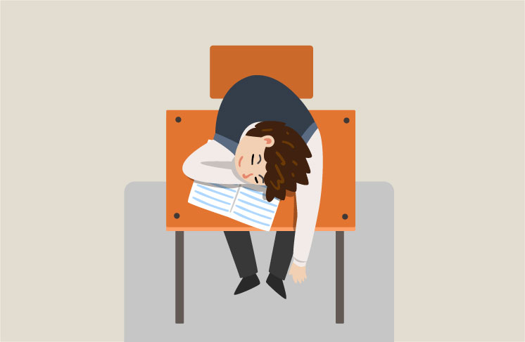 机に突っ伏してやる気が出ないでいる少年