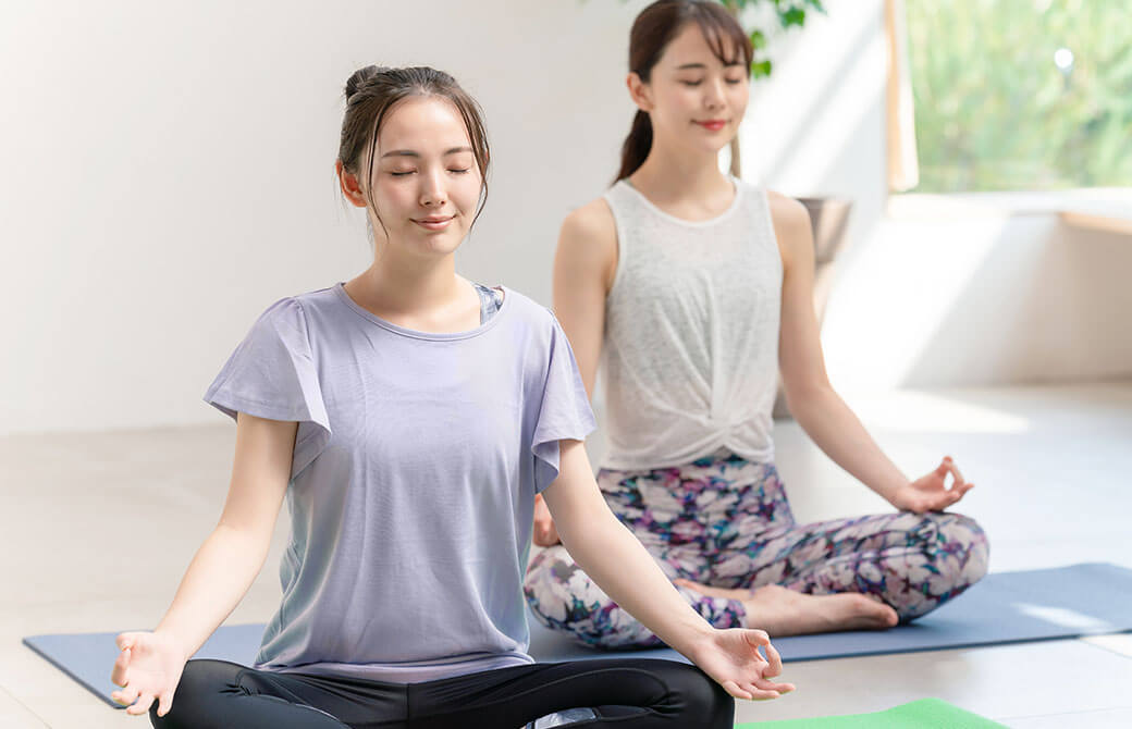 あぐらで瞑想をする女性たち