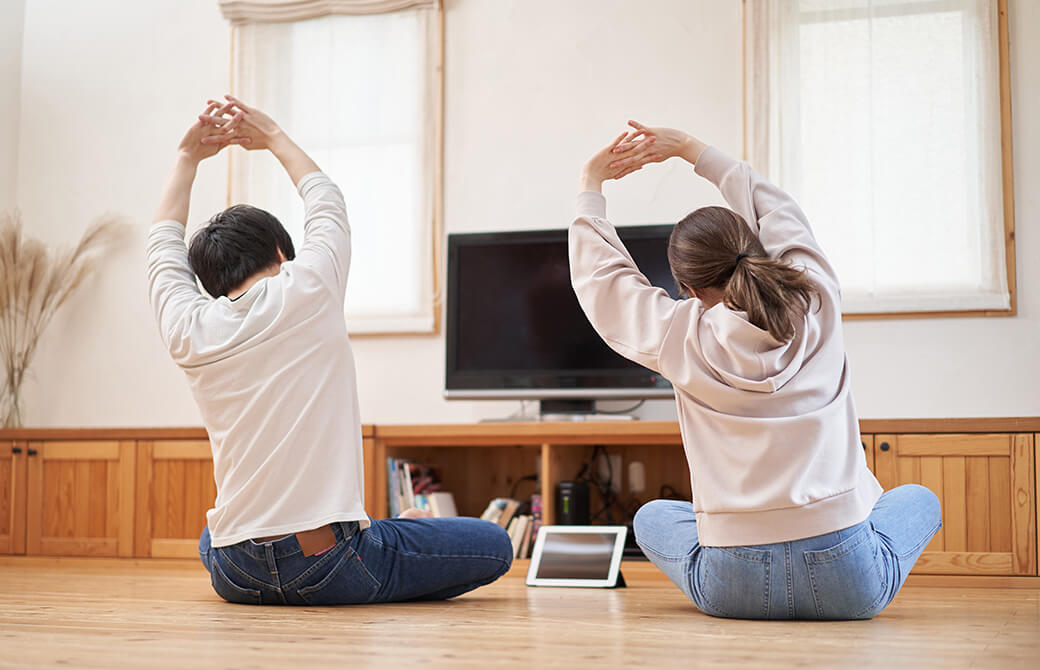 自宅で一緒にオンラインヨガをする女性と男性