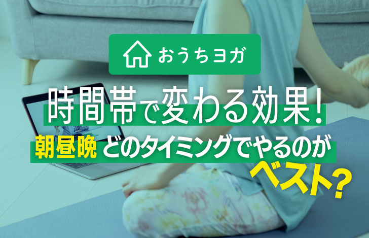 室内でパソコンの画面を見ながらヨガをする女性