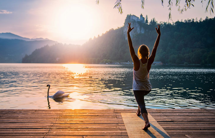 湖畔でヨガをする女性