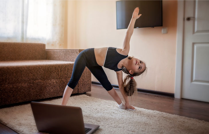 PCの前でヨガを練習する女の子