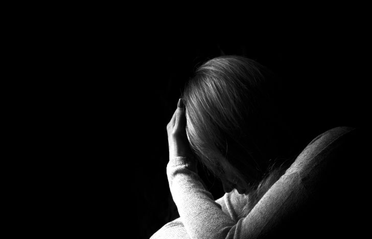 しゃがんで頭を抱える女性