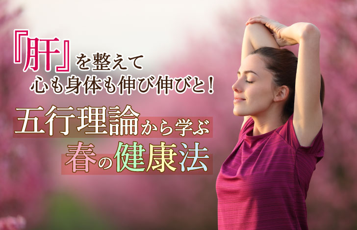 満開の桜の木々に囲まれて深呼吸する女性