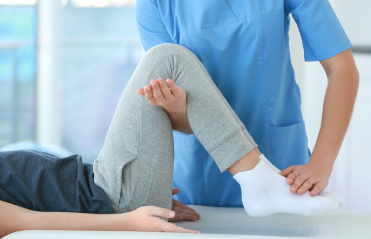 理学療法士が患者の片脚を持ち上げている様子