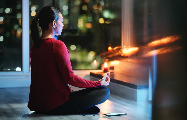 夜の薄暗い室内でヨガをする女性