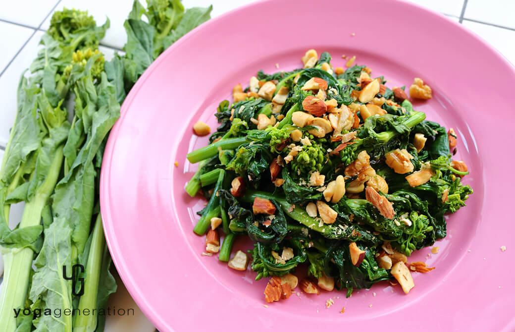 ピンクのお皿に盛り付けた菜の花と色々ナッツの塩炒め