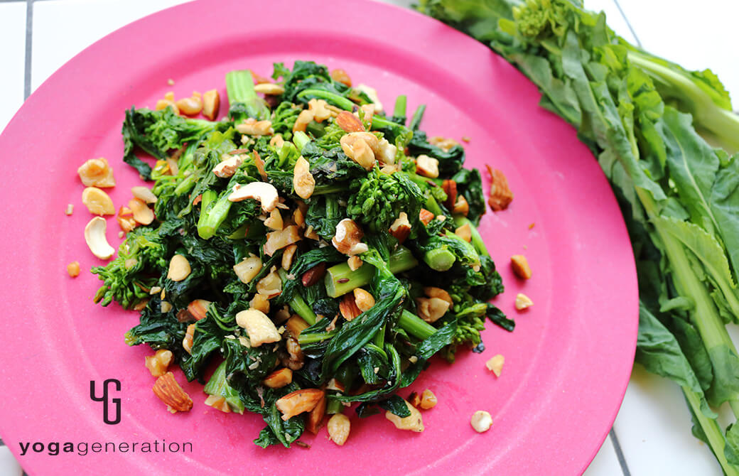 青みがかったピンクのお皿に盛り付けた菜の花と色々ナッツの塩炒め