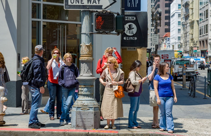 街中の赤信号で立ち止まるアメリカの人々