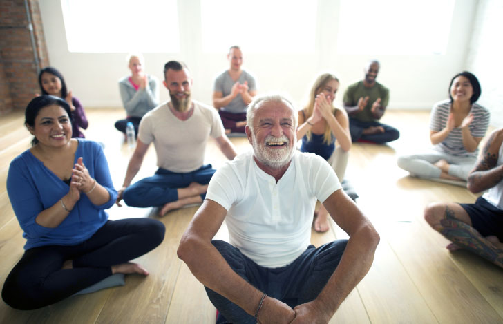 笑顔で床に座り集う老若男女