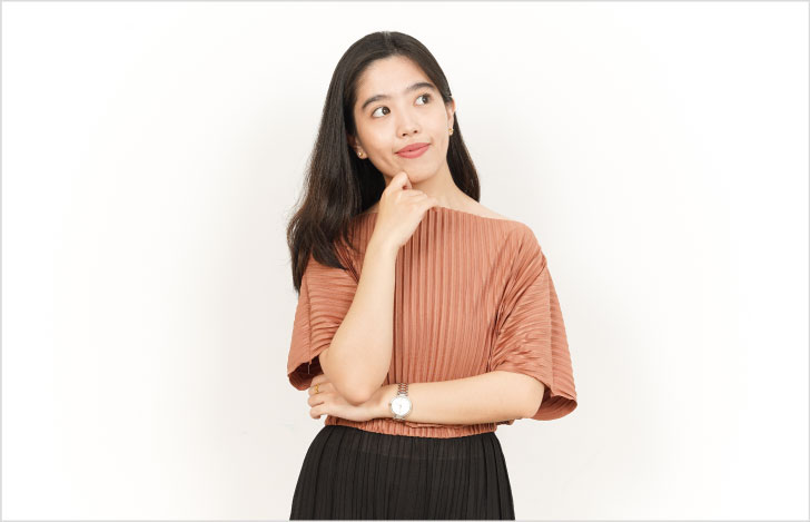 手を顎に当て何かを考える女性