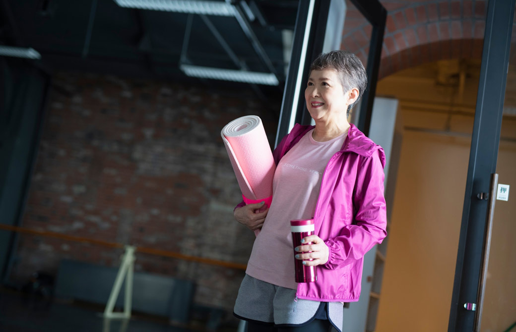 ヨガマットを持ったシニア女