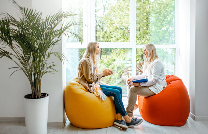 窓辺でカウンセリングを行う二人の女性