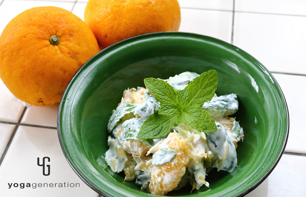 緑の器に盛り付けた夏みかんとキュウリのミントヨーグルトサラダ