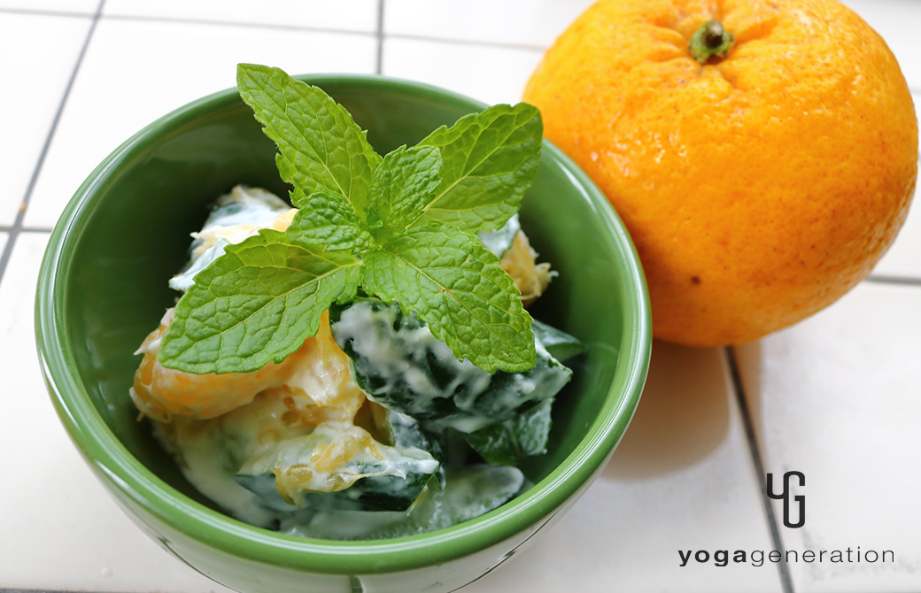 落ち着いた緑の器に盛り付けた夏みかんとキュウリのミントヨーグルトサラダ