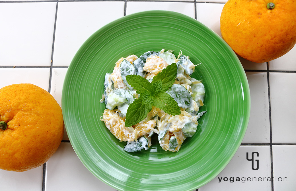黄色が強い緑の器に盛り付けた夏みかんとキュウリのミントヨーグルトサラダ
