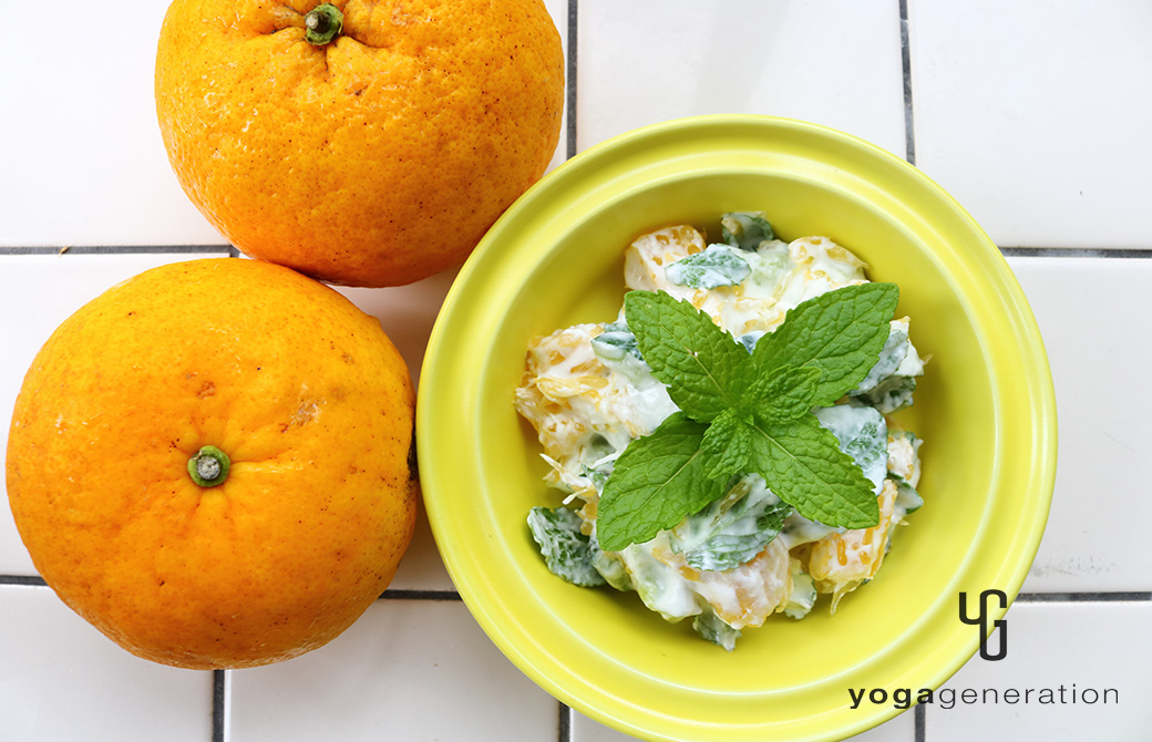 黄色の器に盛り付けた夏みかんとキュウリのミントヨーグルトサラダ