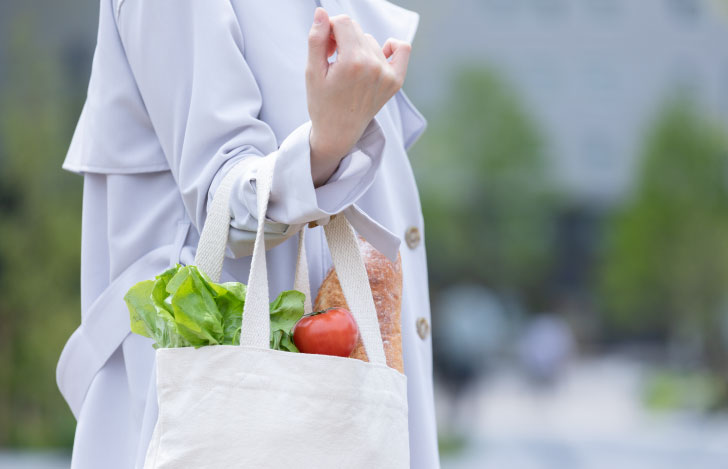 野菜が入ったエコバッグを持つ女性の手元