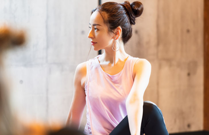 ねじりのポーズをとるヨガウェアを着た女性