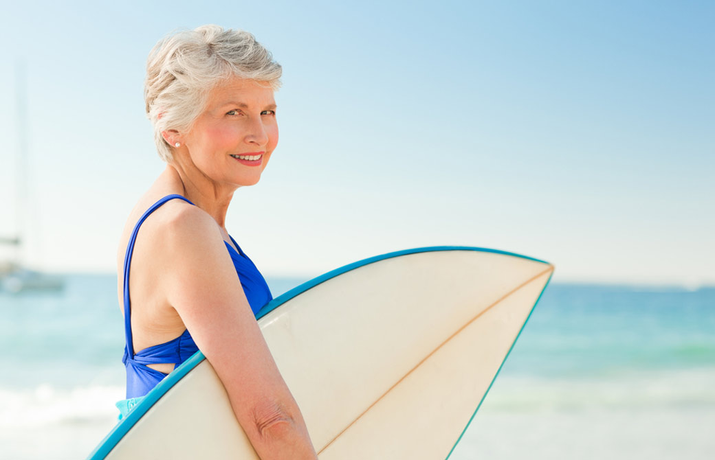 サーフボードを持つシニア女