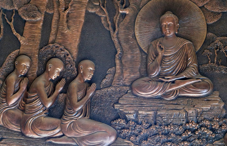 お釈迦様とそのお釈迦様の話に耳を傾ける弟子たちの様子を表す銅のレリーフ