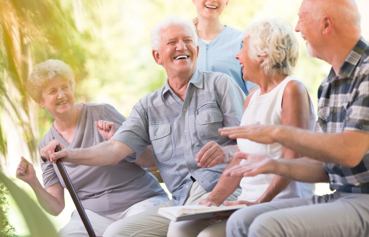 屋外で楽しそうに談笑する白髪のお年寄りの人々