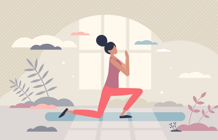 室内のヨガマットの上でヨガを行う女性