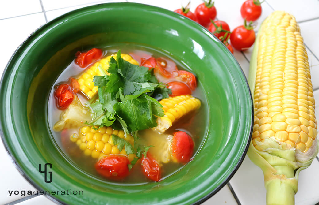 緑色の器に盛り付けたトウモロコシとトマトのアジアン酸っぱ辛スープ