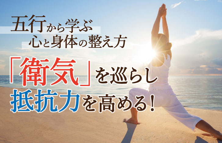 海辺で太陽に向かって戦士のポーズ1をとる白いウェアの女性