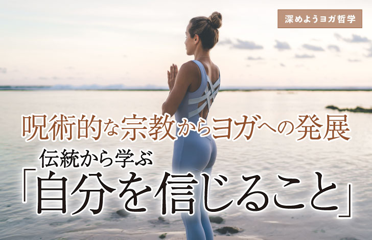 海に向かって両手を合わせて立つ女性の後ろ姿