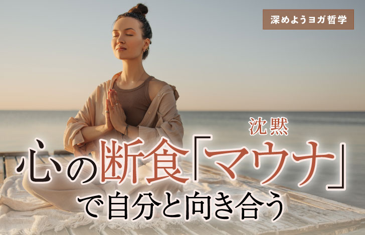 海辺で目を閉じて両手を合わせて座る女性