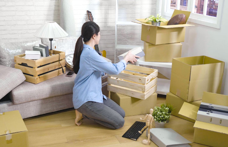 部屋の中を片付ける女性の後ろ姿