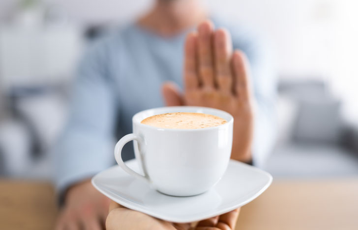 差し出されたコーヒーを断る人の手