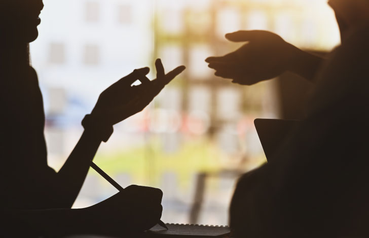 話し合いをする二人の人の手元のシルエット