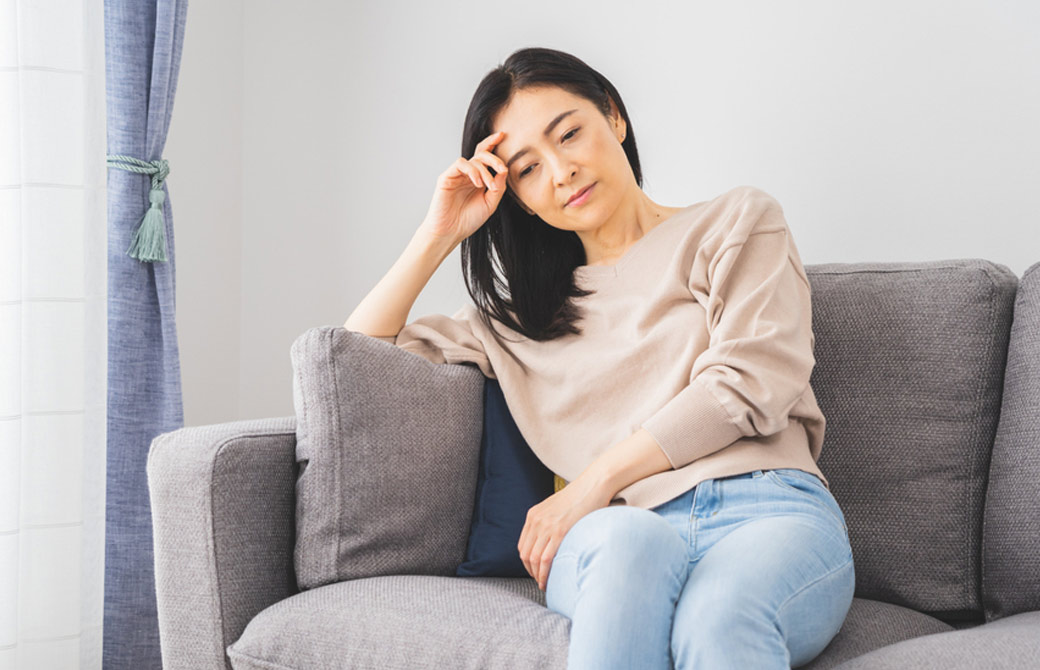疲れてソファーに座る中年女