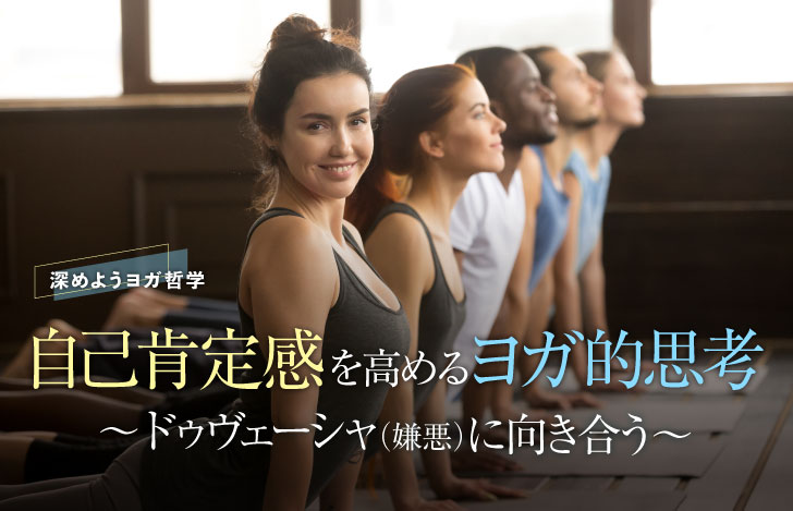 アップドッグをとるヨガの実践者のなかで一人笑顔で目線をこちらへ向ける女性