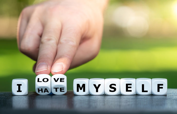 アルファベットが描かれた白いキューブを指で転がす人の手元